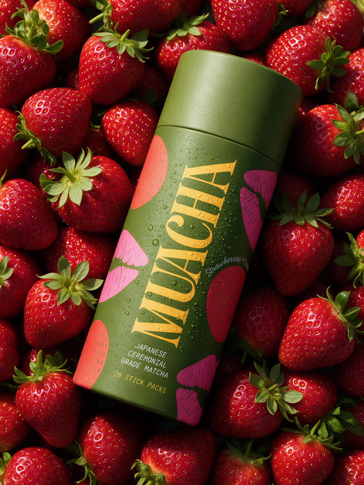 Muacha Strawberries & Cream matcha tube on a bed of strawberries