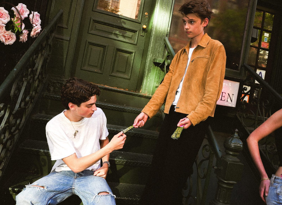 Two people sharing a stick pack on a stoop