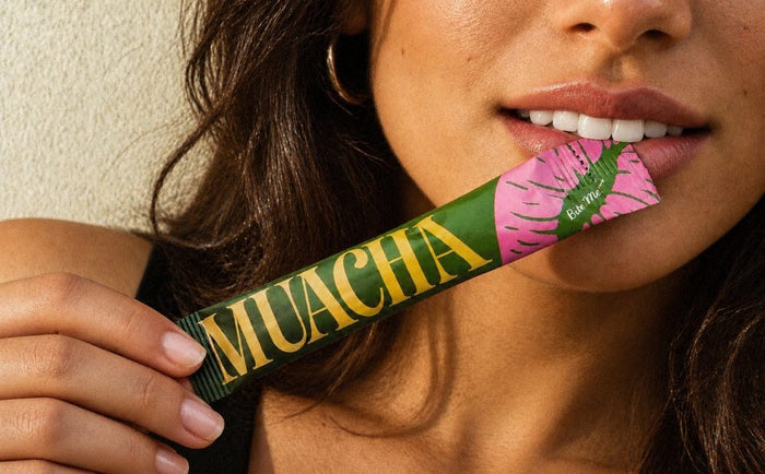 Model biting a Muacha stick pack, close up